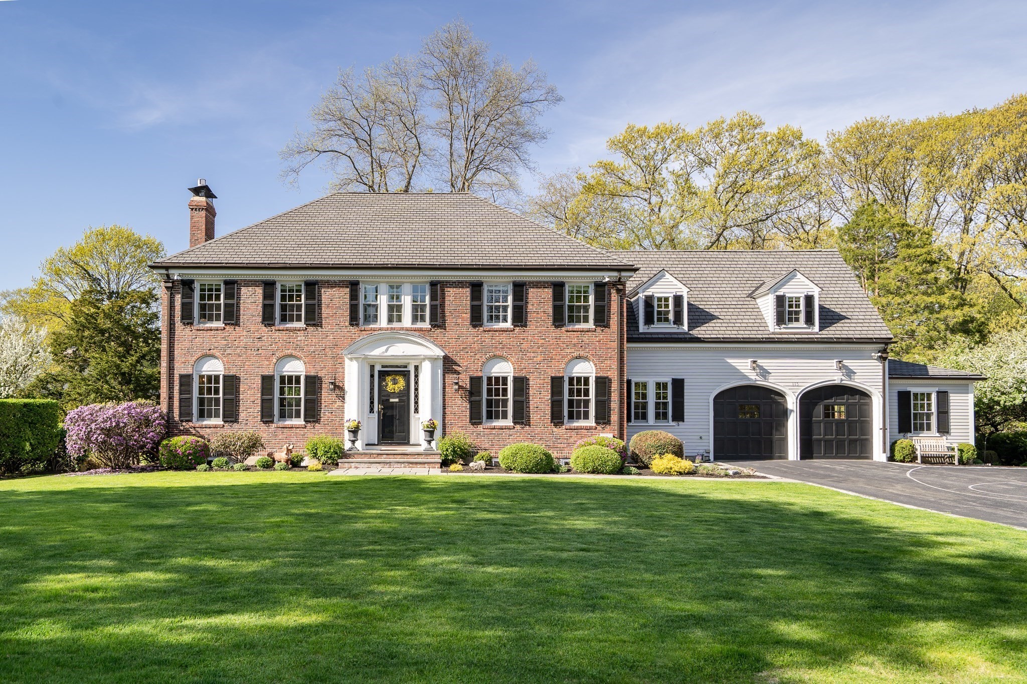 Brick colonial home with a landscaped front lawn